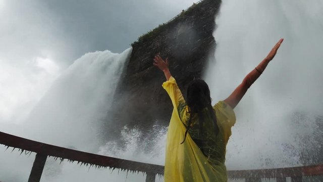 Traveler enjoys waterfall in Cave of the Winds under the Niagara Falls, watered down by waterfall, incredible emotions, travel around the United States
