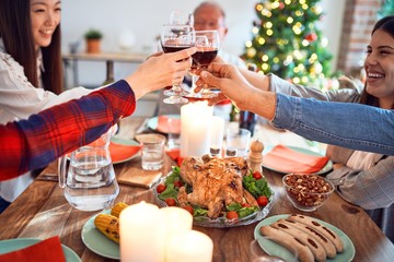 Beautiful family meeting smiling happy and confident. Eating roasted turkey and toasting with cup of wine celebrating Christmas at home