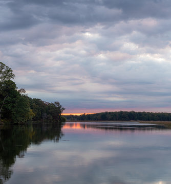 Calm River Landscape at Sunrise with Orange and Pink Clouds