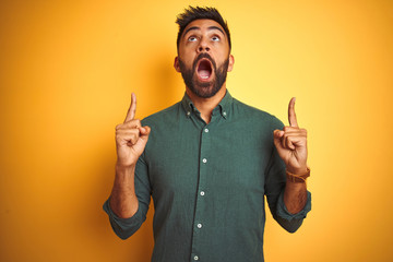 Young indian businessman wearing elegant shirt standing over isolated white background amazed and...