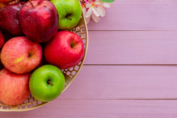 Apples in basket on pink wood. Top view.