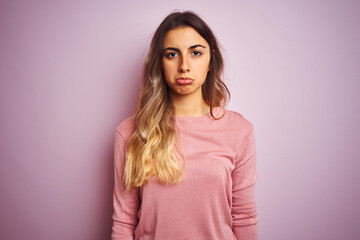 Obraz premium Young beautiful woman wearing a sweater over pink isolated background depressed and worry for distress, crying angry and afraid. Sad expression.