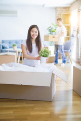 Young beautiful couple open cardboard boxes to order new home