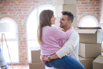 Young beautiful couple hugging in love celebrating very happy moving to new apartment