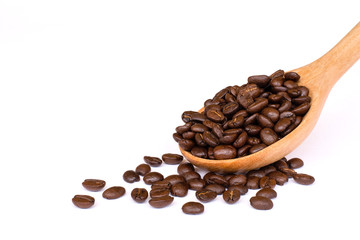 Closeup roasted coffee beans in wooden spoon isolated on white background. Space for text and content.