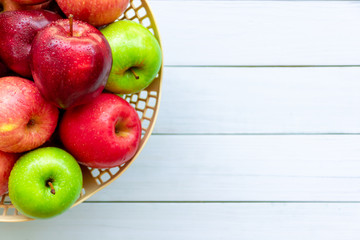Closeup fresh apple fruits in basket isolated on blue wooden table background. Top view. Space for text and content.