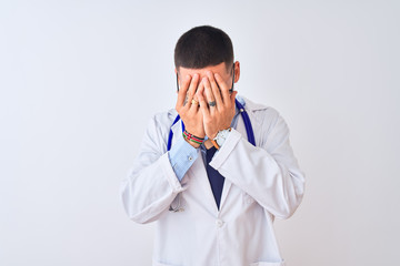 Young doctor man wearing stethoscope over isolated background with sad expression covering face with hands while crying. Depression concept.