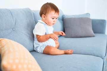 Adorable toddler sitting on the sofa at home