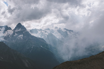 Mountains scene with dramatic cloudy sky in national park of Dombay