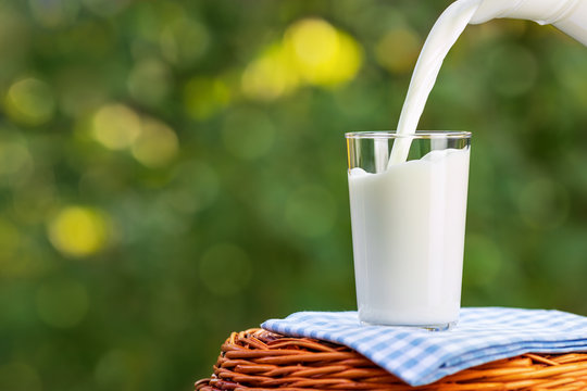 milk from jug pouring into glass