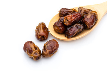 Closeup date palm fruits in wooden spoon isolated on white background. 