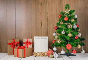 Fototapeta na wymiar christmas tree with colorful balls ornaments and gift boxes with Notebook