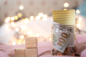 The money collected in the jar contains coins and 100 dollar bills with Credit card Visa -...