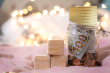 The money collected in the jar contains coins and 100 dollar bills with Credit card Visa -...