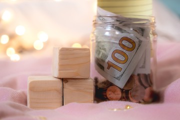 The money collected in the jar contains coins and 100 dollar bills with Credit card Visa -...