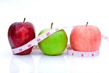 Closeup three fresh mix ripe apples fruits ( red ,green, fuji pink lady apple) with measuring tape isolated on white background. Healthy eating, weight loss, slimming,dieting and healthcare concept. 