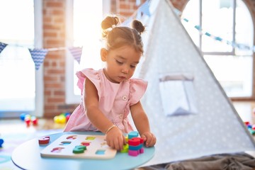 Young beautiful toddler learning mathematics playing with maths game at kindergaten