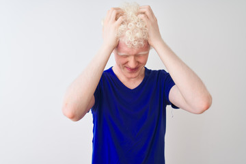 Young albino blond man wearing blue casual t-shirt standing over isolated white background...
