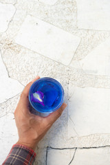 Hand hold butterfly pea water on white table with copy space