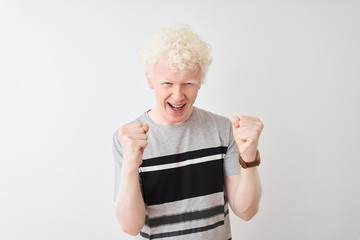 Young albino blond man wearing casual t-shirt standing over isolated white background celebrating...