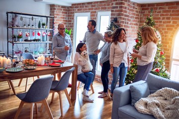 Family and friends dining at home celebrating christmas eve with traditional food and decoration, chatting all together