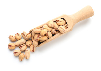 Scoop with tasty pistachio nuts isolated on white
