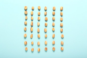Tasty pistachio nuts on color background