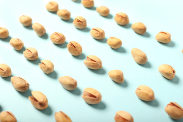 Tasty pistachio nuts on color background