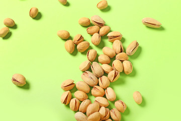 Tasty pistachio nuts on color background