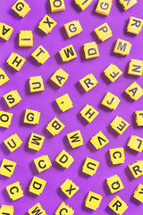 Fototapeta na wymiar Dyslexia word yellow on pink purple with scattered letters cubes around, reading difficulty and disorder visual and auditory memory or test concept. Education and neurology with copy space