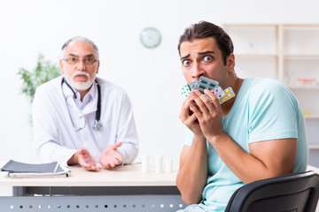 Young man visiting old male doctor