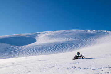 A man drive  snowmobile  in a sunny day, Iceland