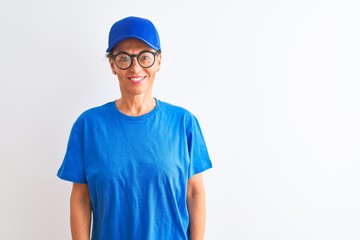 Senior deliverywoman wearing cap and glasses standing over isolated white background with a happy and cool smile on face. Lucky person.