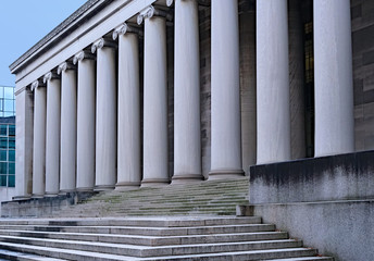 stone university building with steps leading to portico of ionic columns