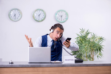 Young man receptionist at the hotel counter