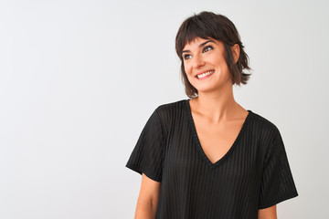 Young beautiful woman wearing black t-shirt standing over isolated white background looking away to side with smile on face, natural expression. Laughing confident.