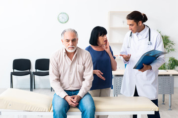 Old couple visiting young male doctor