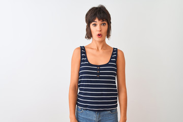 Young beautiful woman wearing striped t-shirt standing over isolated white background afraid and shocked with surprise expression, fear and excited face.
