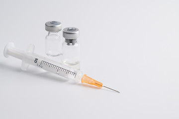 Close up of flu vaccine bottle with syringe injection