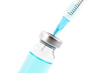 Close up of flu and measles vaccine vials with syringe injection, medicine and drug concept