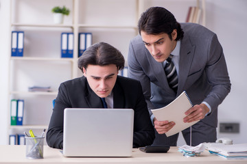 Two young employees working in the office