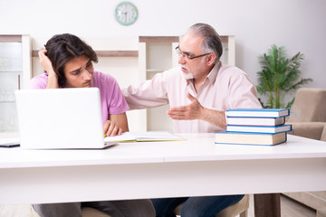 Old father helping his son in exam preparation