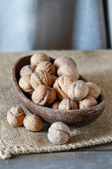 Wooden bowl with walnuts on the table.