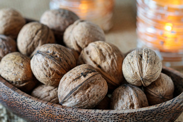 Wooden bowl with walnuts on the table.