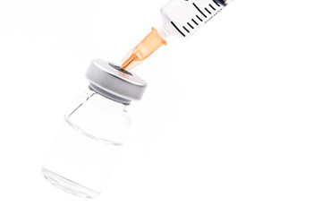 Close up of flu vaccine bottle with syringe injection