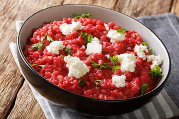 Homemade Italian Orzotto (perlotto) from barley with beets and goat cheese close-up on a plate. horizontal