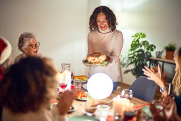 Beautiful group of women smiling happy and confident. Showing roasted turkey celebrating christmas at home