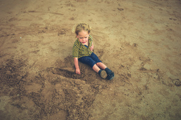 Naklejka premium Little toddler sitting on the beach