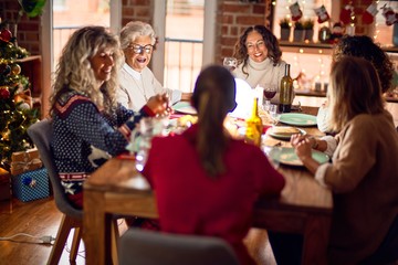 Beautiful group of women smiling happy and confident. Eating roasted turkey celebrating christmas at home