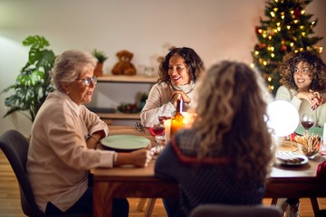 Beautiful group of women smiling happy and confident. Eating roasted turkey celebrating christmas at home